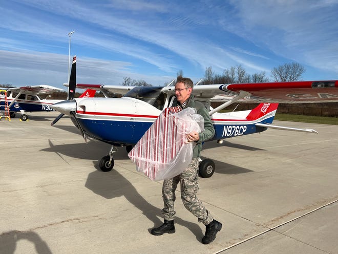 Lt. William VanderMolen unloads gifts from aircraft at West Michigan Regional Airport.