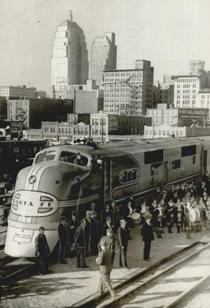 A Santa Fe streamliner rests on the tracks with the Oklahoma City skyline in the background. The stainless steel passenger train had made its first trip into Oklahoma City in December 1939. It soon would be providing 15-hour service to Chicago. The train's debut appearance attracted onlookers, as well as officials who spoke at each stop. More than 6,000 people were estimated to have toured the long, snaking train during its time in Oklahoma City. This photo was published on Dec. 9, 1939, on the front page of The Daily Oklahoman.