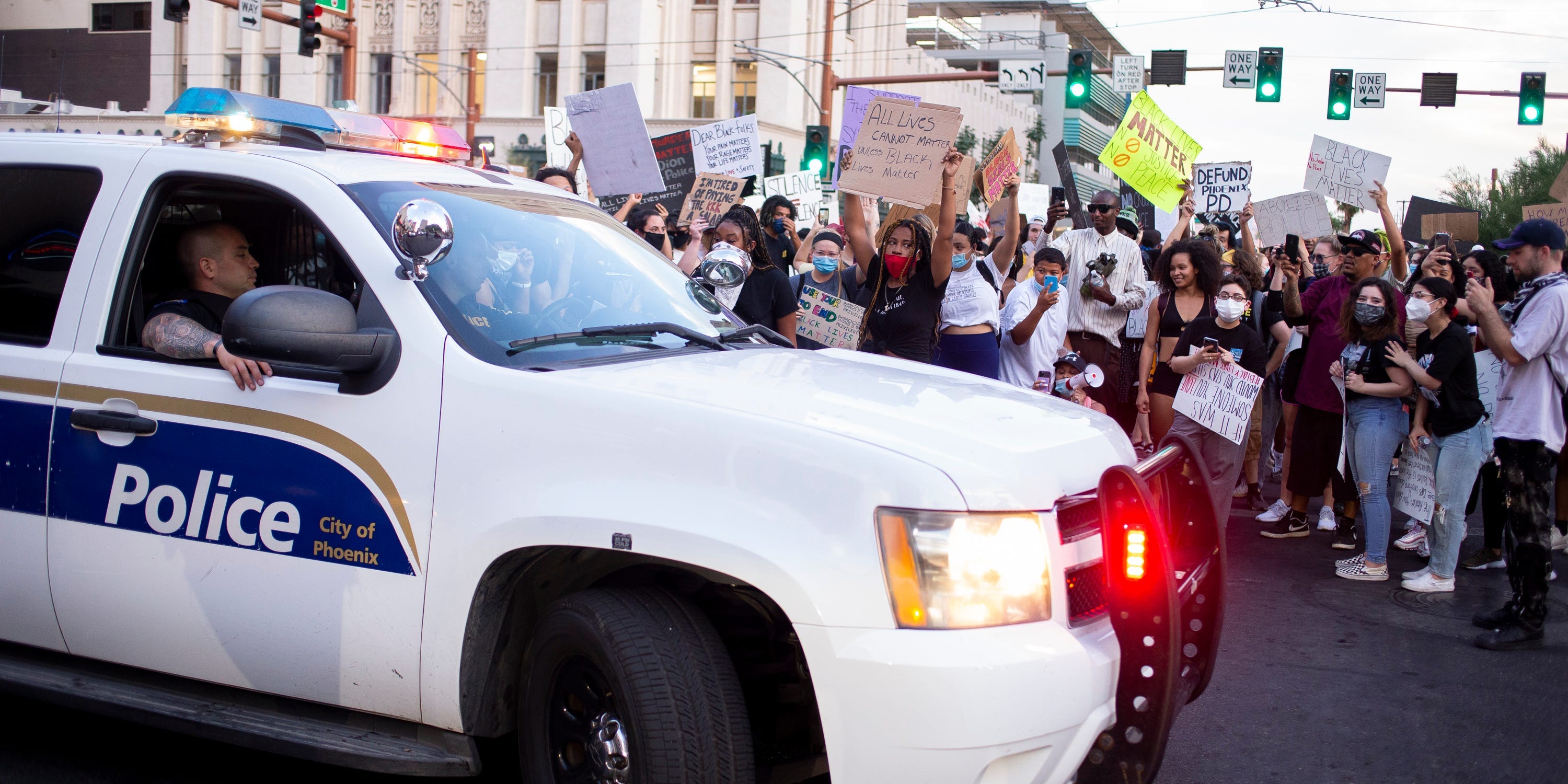 A Phoenix police vehicle is surrounded by protesters on June 4, 2020.
