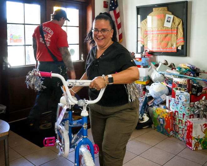 Vilma Troche picks up toys on Dec. 7, 2021 at Fire-Rescue Station No. 1 that were collected for the Farmworker Coordinating Council during last year's Town of Palm Beach United Way toy drive. This year's gifts will go to clients at Achievement Centers for Children and Families, Opportunity Early Childhood Education and Family Center, and The Glades Initiative.
