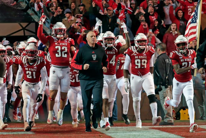 North Carolina State head coach Dave Doeren leads the team onto the field before an NCAA college football game against North Carolina Friday, Nov. 26, 2021, in Raleigh, N.C.
