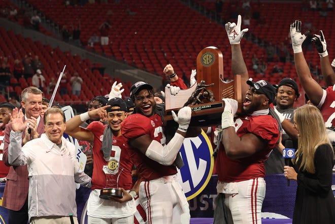 Alabama head coach Nick Saban, quarterback Bryce Young (9), linebacker Will Anderson Jr.  (31), and defensive lineman Phidarian Mathis (48) celebrate with the SEC championship trophy after the Crimson Tide defeated Georgia.