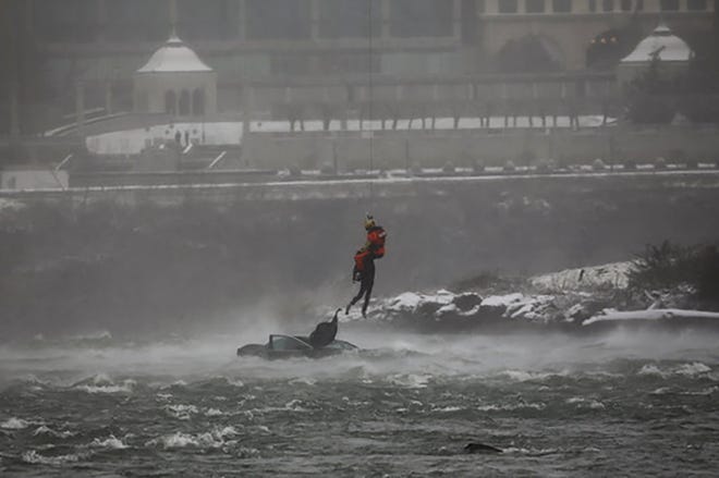 A first responder holds the body of a person who was pulled from a partially submerged vehicle in the Niagara River near the brink of American Falls, Wednesday, Dec. 8, 2021, in Niagara Falls, N.Y.