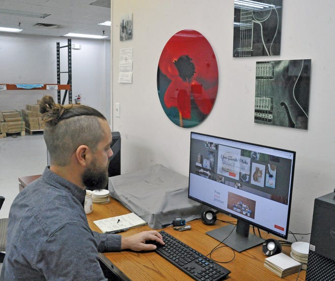 Craig Mast checks incoming orders on the SoulTiles website. The new Wooster business ships photos printed on glass to 48 states. Orders are normally turned around and shipped back to the customer within 24 hours.