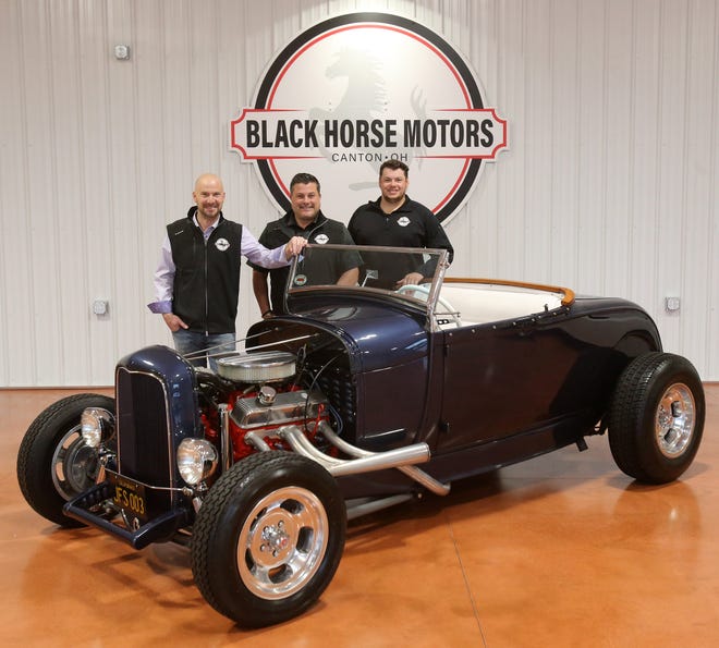 Owners Chris Brosch, left, Phil Dimos, center, and general manager Alex Albini, right, of Black Horse Motors in Jackson Township with a Deuce Coupe that was used in promotional photos with the Beach Boys in 1963. Black Horse anticipates selling the car at auction next month.