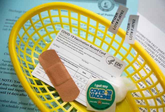 A basket containing a COVID-19 vaccination card is readied for people receiving the Pfizer vaccine at the Sangamon County Department of Public Health vaccination site on Dec. 9, 2021.