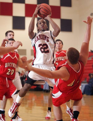 Marion Harding senior Shawn Dyer scores over a falling Jordan Teynor during the Presidents' home game against Bucyrus on Tuesday, Dec. 8, 2009. Two seasons earlier Dyer was a key figure in one of the most memorable games played on Marion County soil.