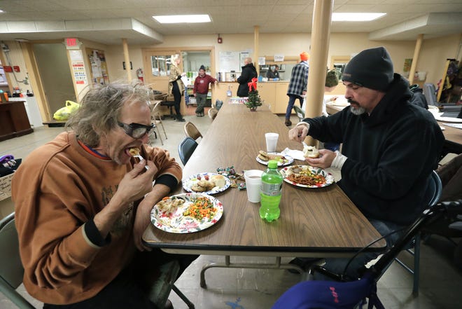 Guests Paul Griesbach, left, and Raymond Adkins enjoy a home-cooked meal Dec. 8 at the Day By Day Warming Shelter, 449 High Ave. The city council approved Tuesday the use of land at Ceape Avenue and Broad Street for a new, year-round shelter.