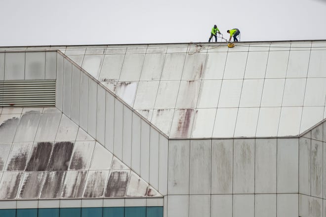 Two workers clean the exterior of the Turlington Building, Thursday, Dec. 9, 2021.