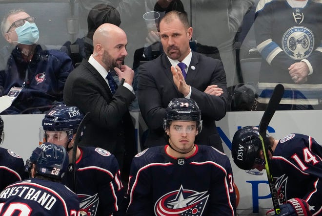 Blue Jackets coach Brad Larsen, here on the right speaking with assistant Pascal Vincent, has entered the NHL's COVID-19 protocols. Vincent will take over in Larsen's absence.