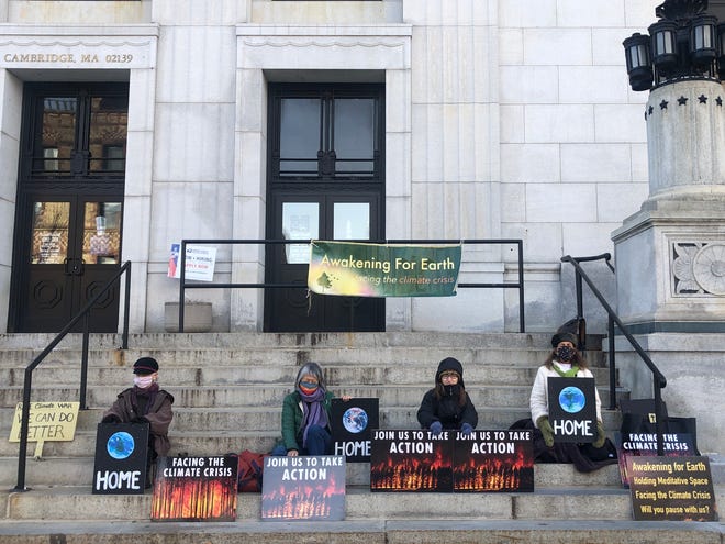 Meditators from Awakening for Earth sit outside the Central Square post office in Cambridge on Sunday, Dec. 5.
