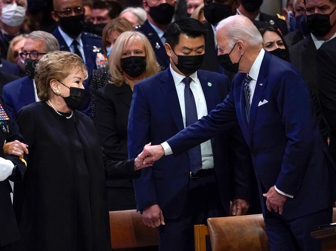 President Joe Biden reaches out to Elizabeth Dole as she arrives for the funeral service of her husband, former Sen. Bob Dole at the Washington National Cathedral in Washington D.C. on Dec. 10, 2021.