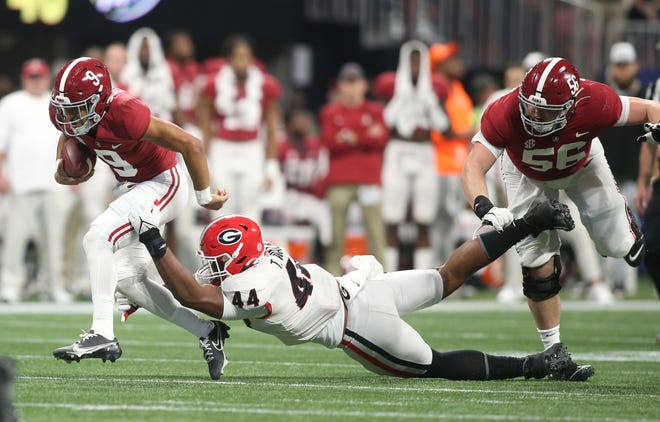 Alabama quarterback Bryce Young runs past Georgia defensive lineman Travon Walker in the first half of the SEC championship game last week. Young's big performance in that victory was a perfect finish to his Heisman Trophy campaign.