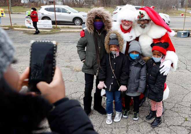 Siblings A'Kiahla Wright, 11, left, Naomi Wright, 6, Kaden Wright, 4 ,and Kyndall Wright, 4, have their picture taken by their mother, Anniesha Joyce, 30, with Santa and Mrs. Claus on Saturday, Dec. 11, 2021. Saunders Memorial A.M.E. Church in Detroit held the vaccination effort pop-up, along with Michigan United.