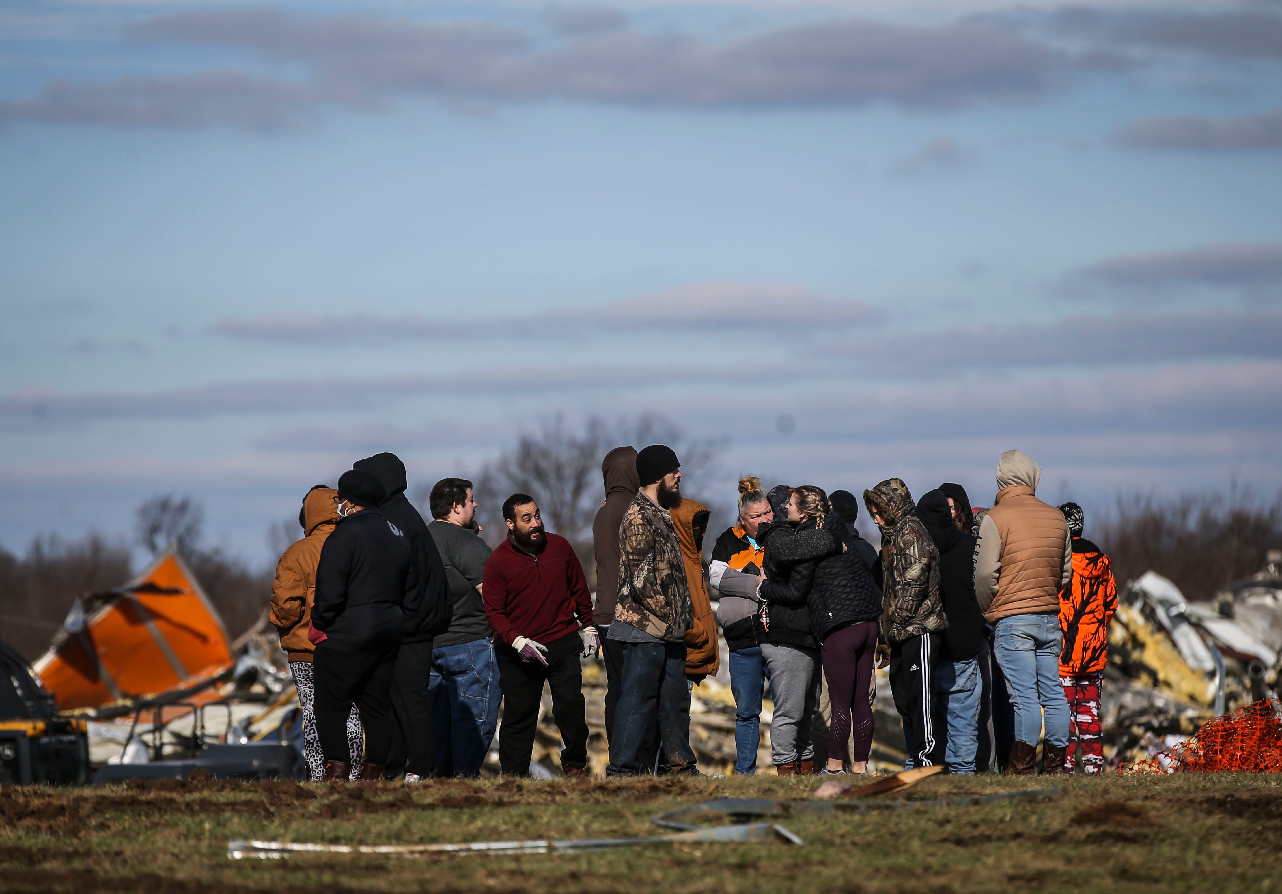 Family and loved ones gather outside the remains of a candle factory that was destroyed after a deadly tornado ripped through Mayfield, Ky. on Friday, Dec. 10, 2021. At least eight people inside the factory were killed.