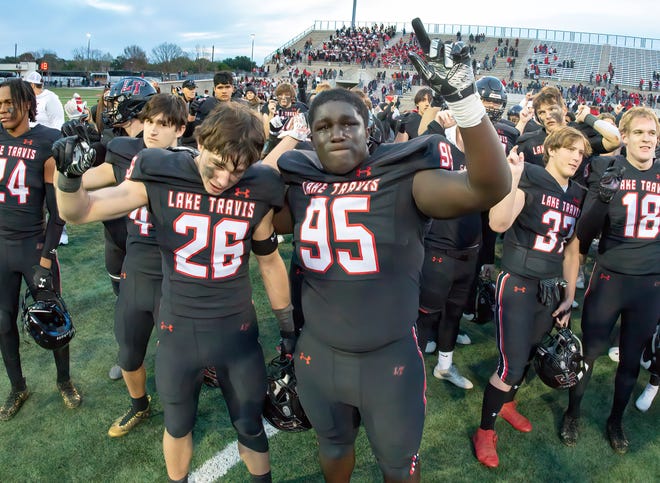 Lake Travis defensive tackle Jacob Henry, right, and defensive back Jayden Walker salutes the Cavalier fans after falling to eventual state champion Galena Park North Shore in a Class 6A Division I state semifinal last December. Henry, the son of professional wrestler Mark Henry, enjoyed a viral summer in the weight room and says the Cavs are poised for a long playoff run.