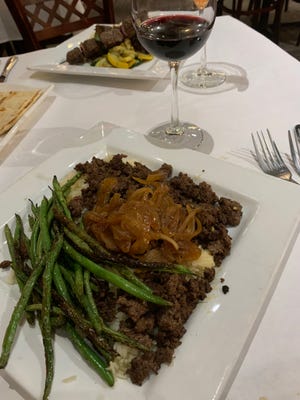Beef shawarma is served over basmati rice and topped with caramelized onions, with a side of green beans at Laziza in Kent.