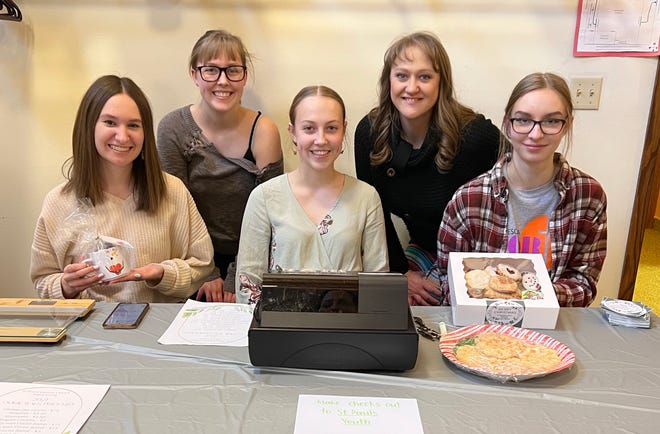Katlynn Vonderharr, Evangeline Torgerson, CarrieAnne Boetcher, Abigail Torgerson, and Liz Torgerson, adult leader for the youth group, staffed the check-out area at Sunday's Cookie Walk.