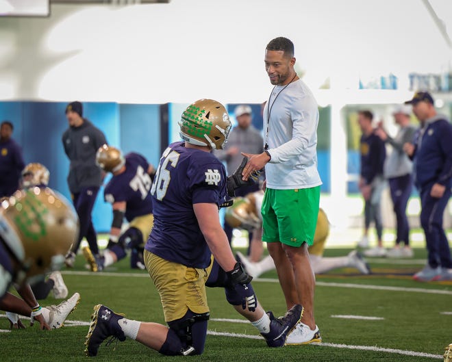 Head Coach Marcus Freeman has a chat with OL John Dirksen (56) during Notre Dame football practice for the Fiesta Bowl on Sunday, Dec. 12, 2021, inside the Irish Athletics Center at Notre Dame in South Bend.