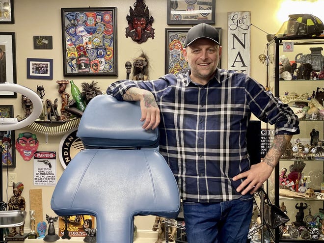 Owner of Zaza Ink, Joe Peterson, surrounded by an eclectic array of gifts from his tattoo customers.