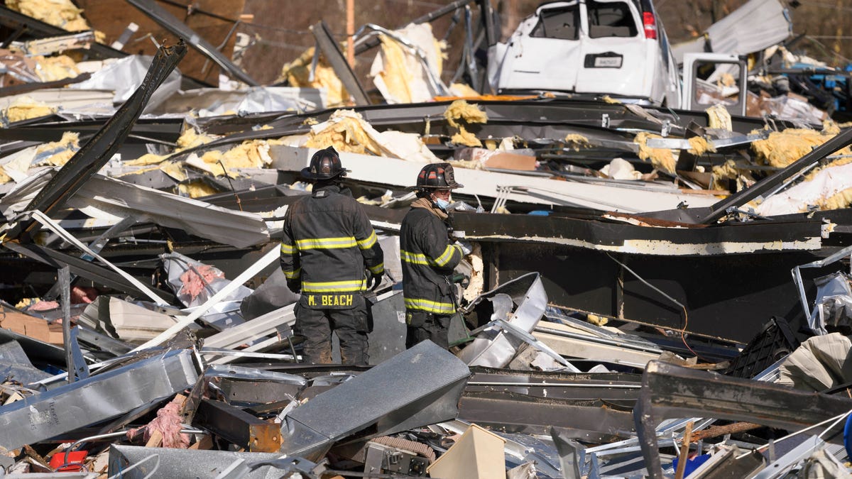 Emergency workers search through what is left of the Mayfield Consumer Products Candle Factory after it was destroyed by a tornado in Mayfield, Kentucky, on Dec. 11, 2021.