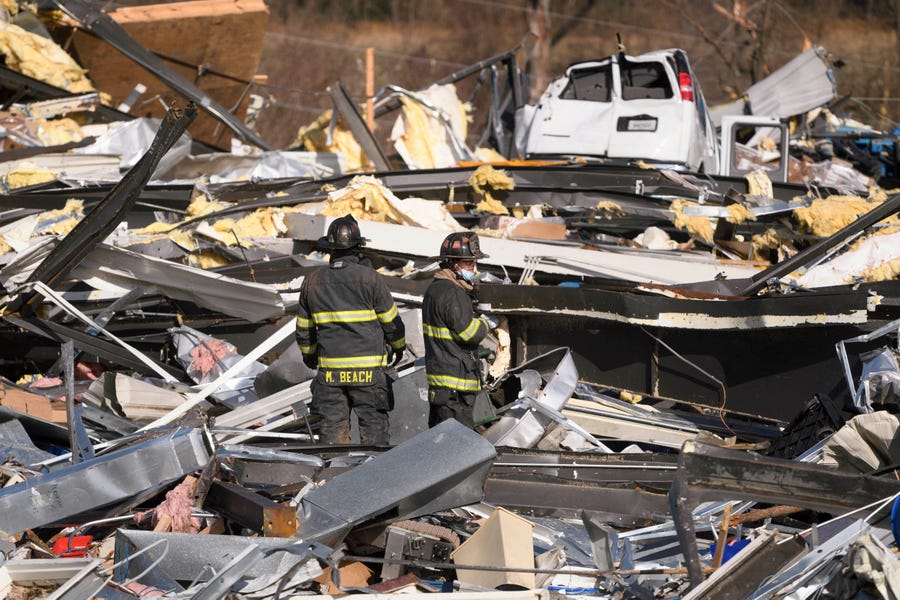 Emergency workers search through what is left of the Mayfield Consumer Products Candle Factory after it was destroyed by a tornado in Mayfield, Kentucky, on Dec. 11, 2021.