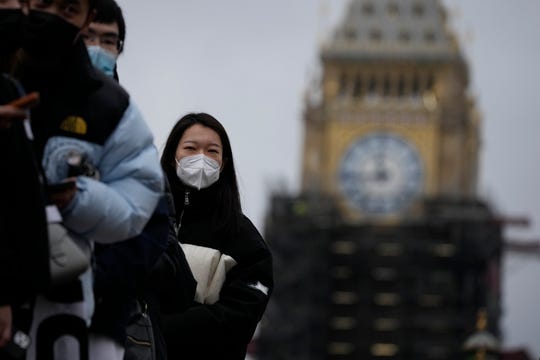 People wait in line for a coronavirus booster shot on Monday at London's St. Thomas' Hospital, backdropped by the scaffolded Elizabeth Tower, known as Big Ben, and the Houses of Parliament.