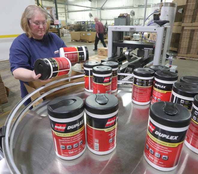 Malco employee Stephanie Albright packs newly labeled containers of Duplex, a heavy-duty cleaning wipe and degreaser on Dec. 14 in Barberton.