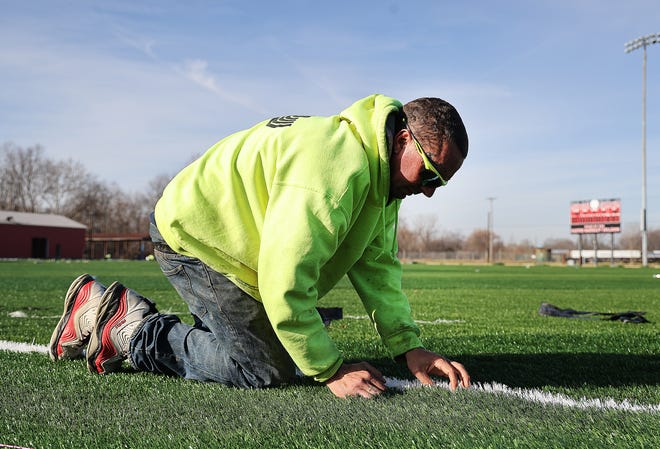Randall Crowe with The Vasco Group works on the infield turf installation at Thurman Munson Stadium in Canton. The Canton City School District and the city of Canton have pledged to invest roughly $5 million to improve the former minor-league stadium.