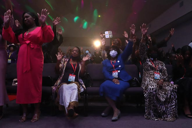 Attendees lift their hands in prayer during the United Assembly of Christian Churches Holy Convocation at Upper Room Ministries in Gainesville. The theme of the convocation was "Blessed in the City."