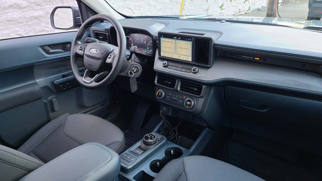The interior of the 2022 Ford Maverick has character with a tablet screen, storage, and rotary shifter.