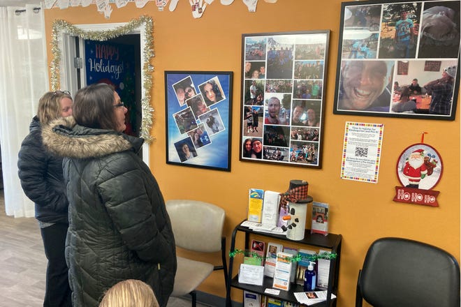 Provoking Hope employees Anne Muilenburg, right, and Debra Cross, look at photos of people who have died of drug overdoses or suicide in the lobby of the recovery center in McMinnville.
