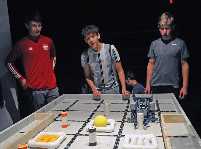 Jack Maibach (left), Isaiah Steiner (center) and Kolton Miller of Norwayne High School watch as their robot grabs a container of pingpong balls. Maibach, who is a sophomore, said their robot didn't win the first match but he has enjoyed competing and looks forward to continuing in the robotics program next year.