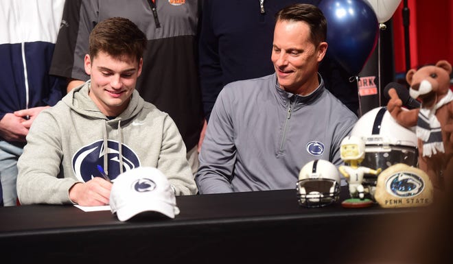Central York senior quarterback Beau Pribula (left) signs his national letter of intent to play football for Penn State as his father, Tad, looks on Wednesday, Dec. 15, 2021 at Central York High School.