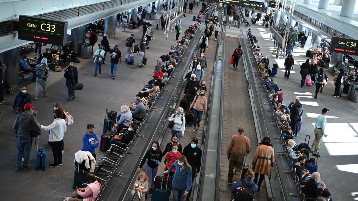 Travelers are seen at Denver International Airport in this file photo from Nov. 30, 2021.