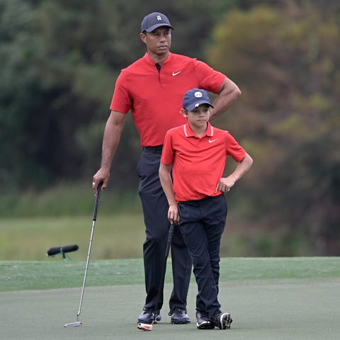 Tiger Woods and his son Charlie wait to putt on th