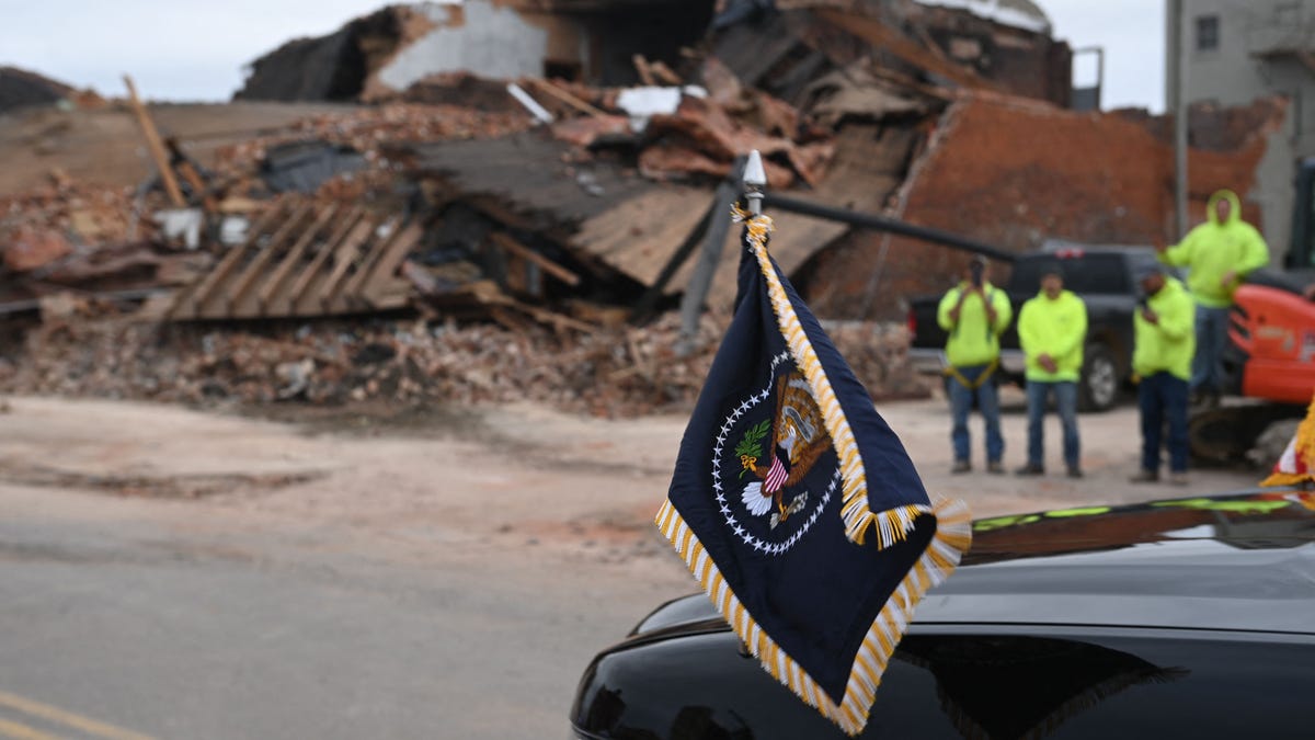A vehicle carrying President Joe Biden passes rubble from a tornado in Mayfield, Ky., on Dec. 15.