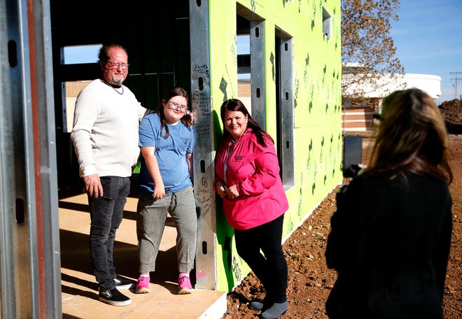 From left to right David Dodd, Sahara Dodd and Monique Dodd pose for a photograph after signing a beam at the Transition Center at Deer Creek High School, Tuesday, Dec. 14, 2021. 