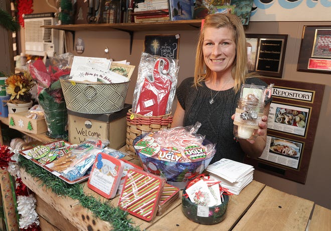 Jamie Clendenin shows some of the candles and other gifts available in her Canton Township shop, Essential Wix.