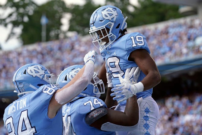 North Carolina tight end Garrett Walston, left, and offensive lineman Jordan Tucker celebrate with running back Ty Chandler, right, after Chandler scored a touchdown against Duke in October.