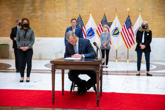 Gov. Charlie Baker signs "An Act Promoting a Resilient Health Care System That Puts Patients First" atop Beacon Hill on Jan. 8, 2021.