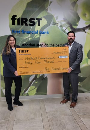 Misty De La Cruz, left, and Michael Schneider of Northwest Indiana Reinvestment Alliance in Lafayette, Ind., celebrate a grant from First Financial.