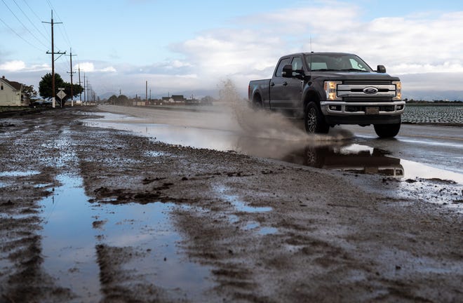 A truck drives through a puddle of water making a splash on S. Davis Road in Salinas, Calif., on Thursday, Dec. 16, 2021. 