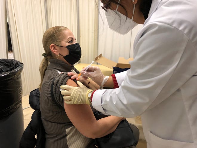 Cynthia Mercado teaches sixth grade at El Dorado school in the East Ramapo school district. She received a COVID booster from pharmacist Rupal Dar of TruCare Pharmacy during a Dec. 7, 2021 vaccine clinic at Kakiat school in Spring Valley.