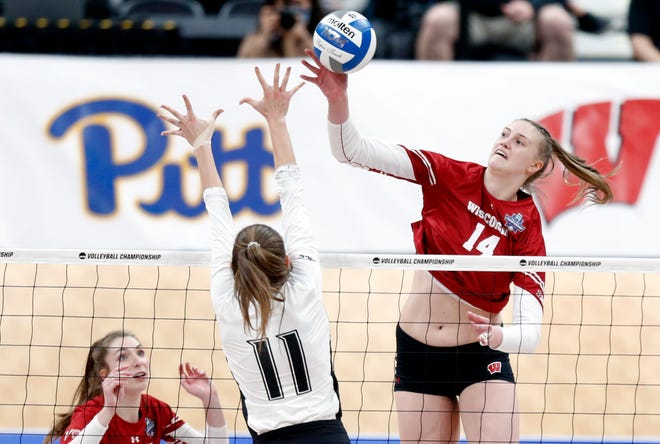 Wisconsin's Anna Smrek, right, spikes the ball against Louisville during a semifinal of the NCAA women's college volleyball tournament.