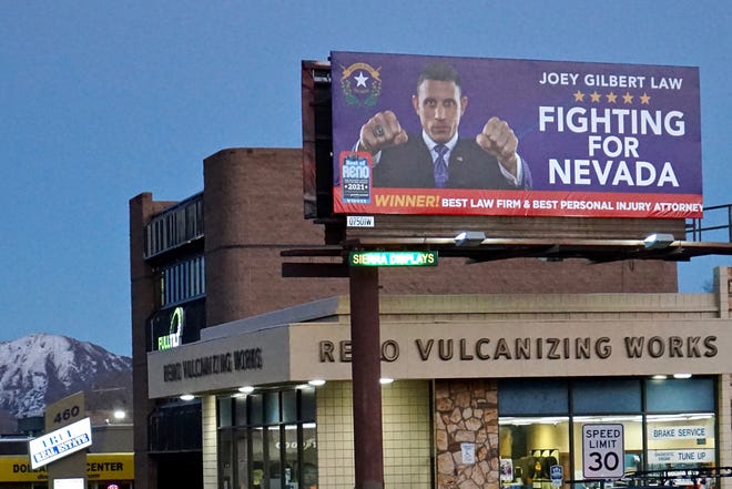 A billboard advertises legal services for Joey Gilbert, an attorney and former professional boxer, who is running for governor of Nevada, in Reno, Nev., on Dec. 16, 2021. A disciplinary panel sent Republican Joey Gilbert a draft letter of reprimand alleging he had harmed a client by not supervising a law student assigned to his case.