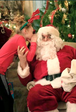 Jordyn Calhoun of Winnebago whispers her Christmas wish into the ear of Michael Cross, otherwise known as “Santa Cross.” Cross has been playing Santa Claus the past 10 years.