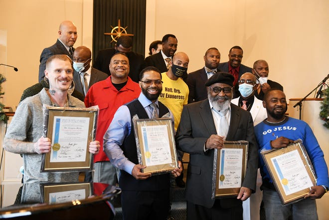 Honorees Gregory Berry, left, Juwan Deering, Raymond Gray and Chamar Avery hold their Spirit of Detroit awards at the service at United Kingdom Church on Sunday. Standing with them are past honorees and those who are celebrating the men's release from prison.