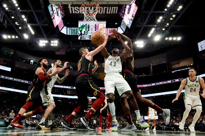 The Bucks' Thanasis Antetokounmpo is fouled as he shoots between Cleveland Cavaliers' Kevin Love and Ed Davis during the second half  Saturday night at Fiserv Forum.