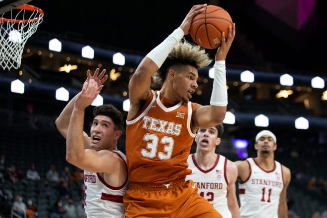 Texas forward Tre Mitchell jumps to pass while Stanford guard Michael O'Connell, left, defends with Stanford forwards Maxime Raynaud (42) and Jaiden Delaire (11) look on during the Longhorns' 60-53 win Sunday in Las Vegas. Mitchell had six points and five rebounds in the victory.
